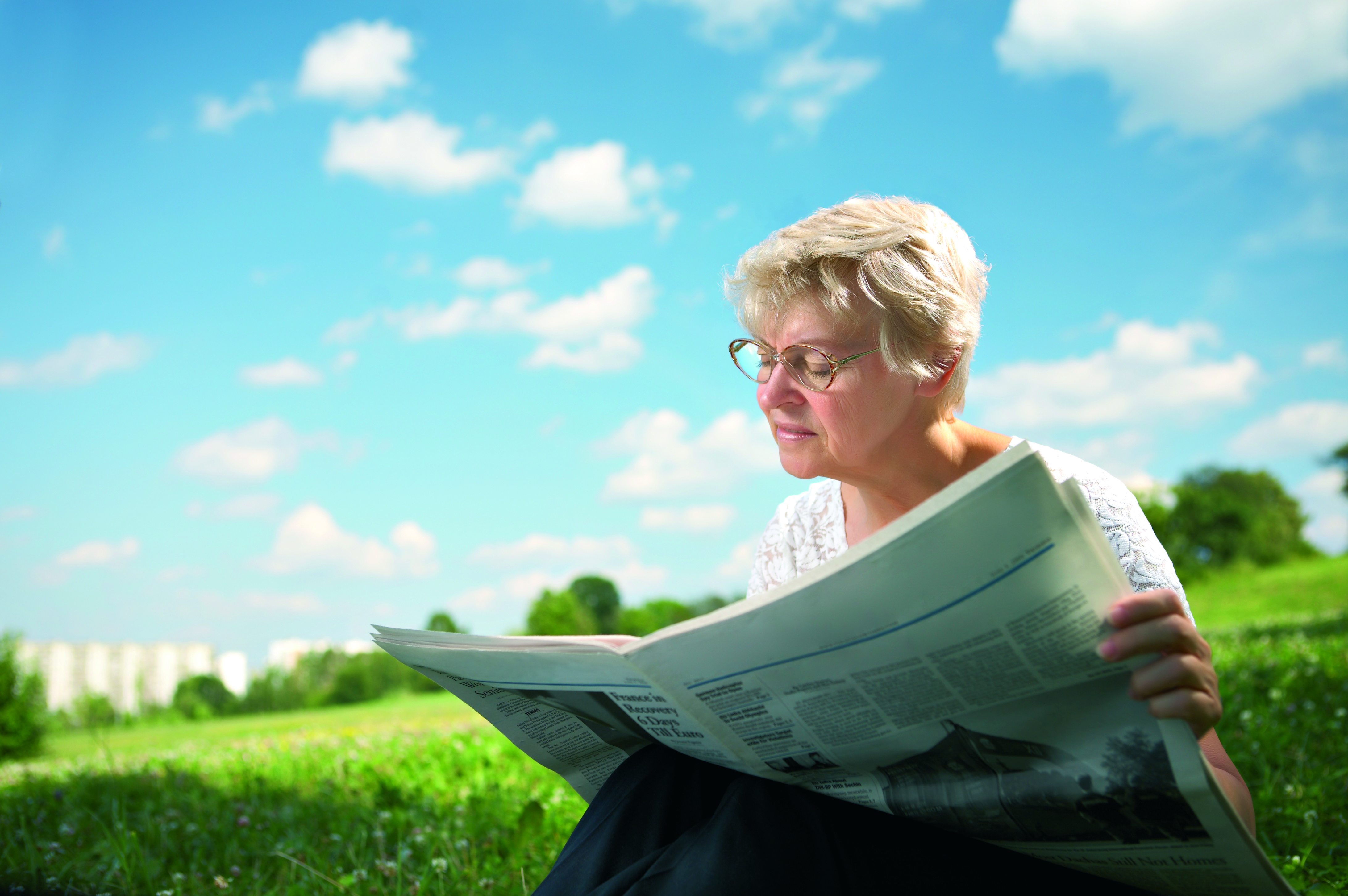 old woman reading a newspaper