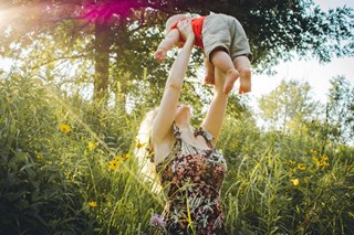 woman lifting baby in the air