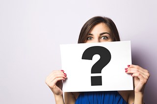 woman holding up paper question mark