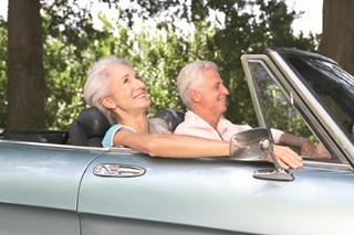 elderly couple enjoying convertible car