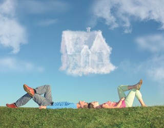 Couple lying under cloud the shape of a house