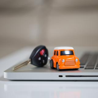 Toy car and a set of keys on top of a laptop