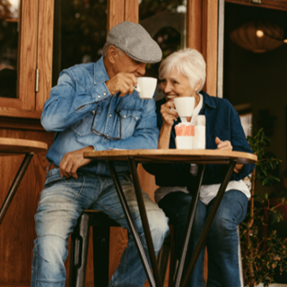 elderly couple drinking coffee outside