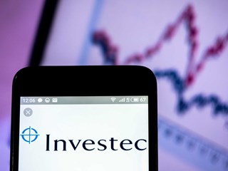 Investec logo on phone screen with graph displayed behind