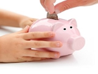 person adding coin to pink piggy bank