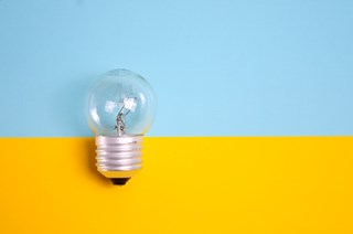 light bulb in front of yellow and blue background