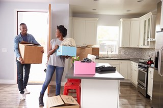 man and woman holding boxes in kitchen