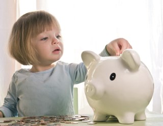child placing money in piggybank