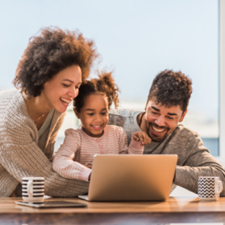 family of three smiling at the laptop