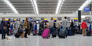 people waiting in a large queue at the airport
