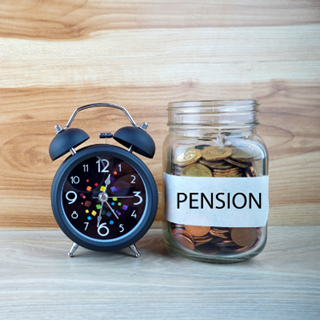 Pension jar with classic alarm clock beside it