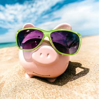 Piggy bank on a beach in sunglasses