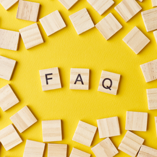FAQ written on wooden tiles on yellow background