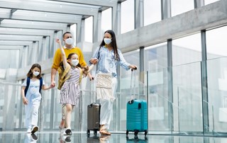 a family walking through an airport with masks on their faces