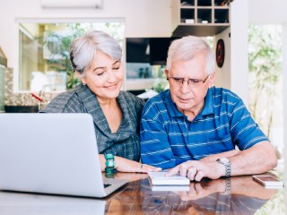 elderly couple sitting at their computer