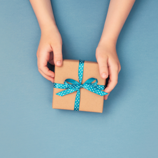 Hands holding a present box wrapped in blue ribbon