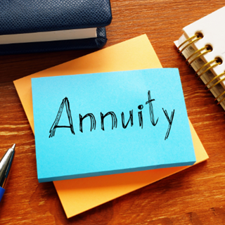 Blue sticky note on a desk with the word 'Annuity' written on it
